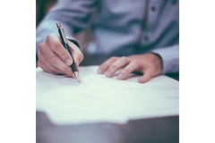 Image Man signing paper.